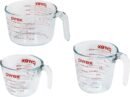 Pyrex 3-piece glass measuring cup set showing 1-cup, 2-cup, and 4-cup sizes with red ounce and milliliter markings, easy-grip handles, and pouring spouts. Tempered glass, microwave and dishwasher safe.